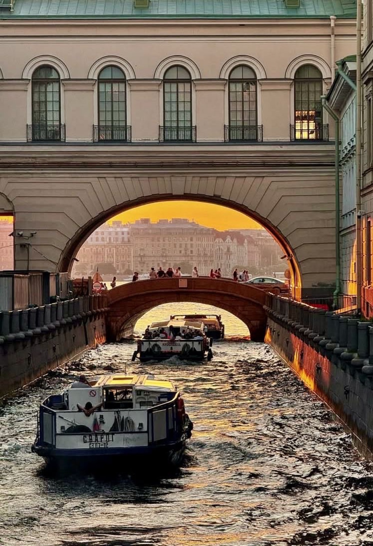 Золотой закат над каналом и лодками в Петербурге